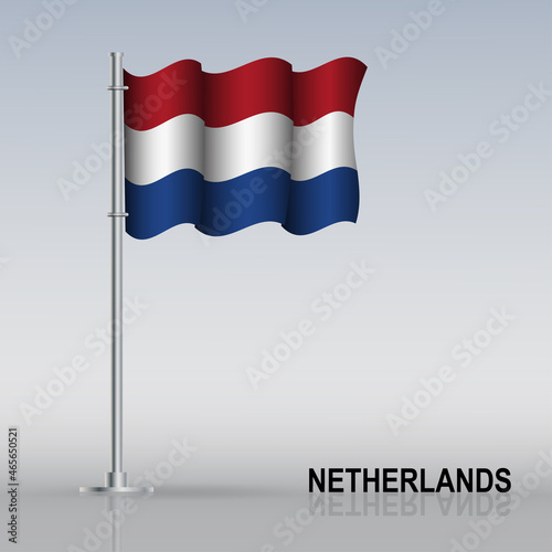 Flag of Netherlands flying on a flagpole stands on the table