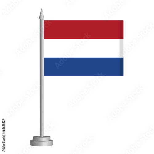 Flag of Netherlands flying on a flagpole stands on the table