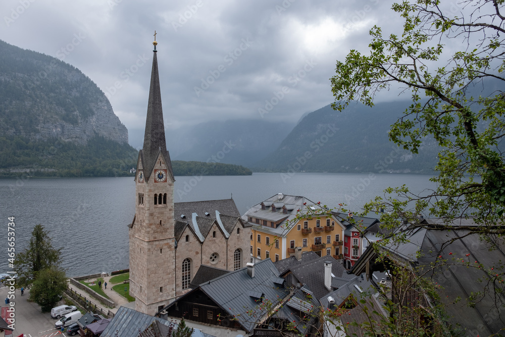 Hallstatt Lutheran Church and buildings roofs with lake and mountains at the background, in a cloudy autumn day. Austrian state of Upper Austria.