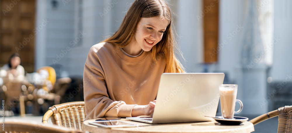 Freelancer surf the internet information. The designer communicates with friends online. An entrepreneur prints a message on a social network. A female programmer is sitting in a summer cafe.