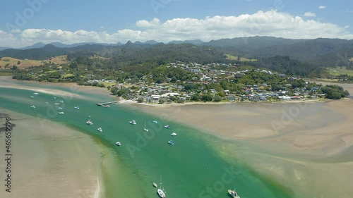 Aerial: Tairua harbour, boats docked and beach. Coromandel Peninsula, New Zealand photo