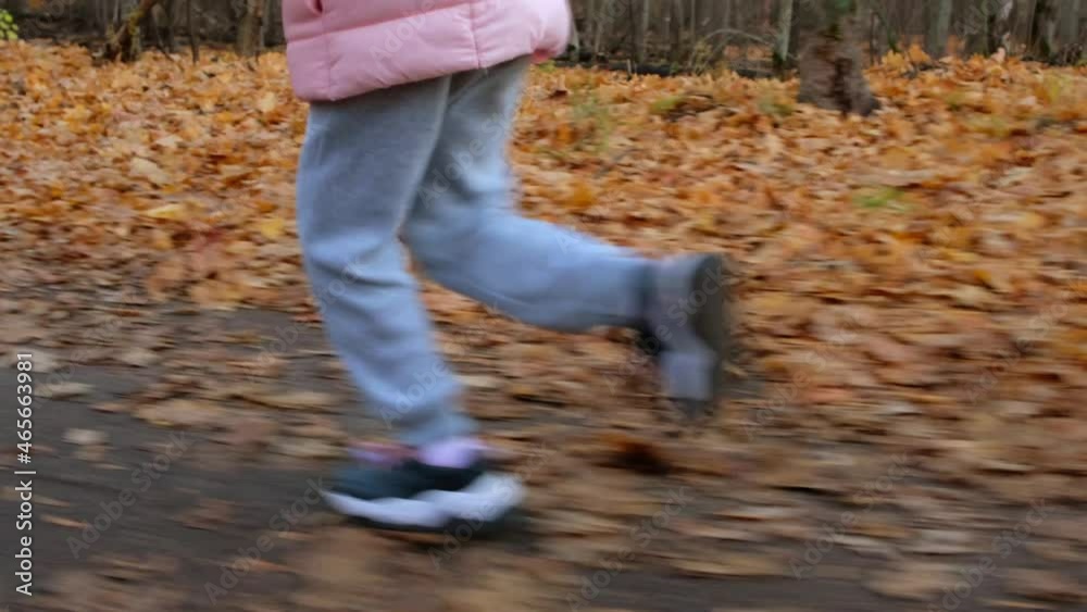 Little girl running in autumn forest. Child is jogging in park. Little girl running in autumn forest. Child is jogging in park.