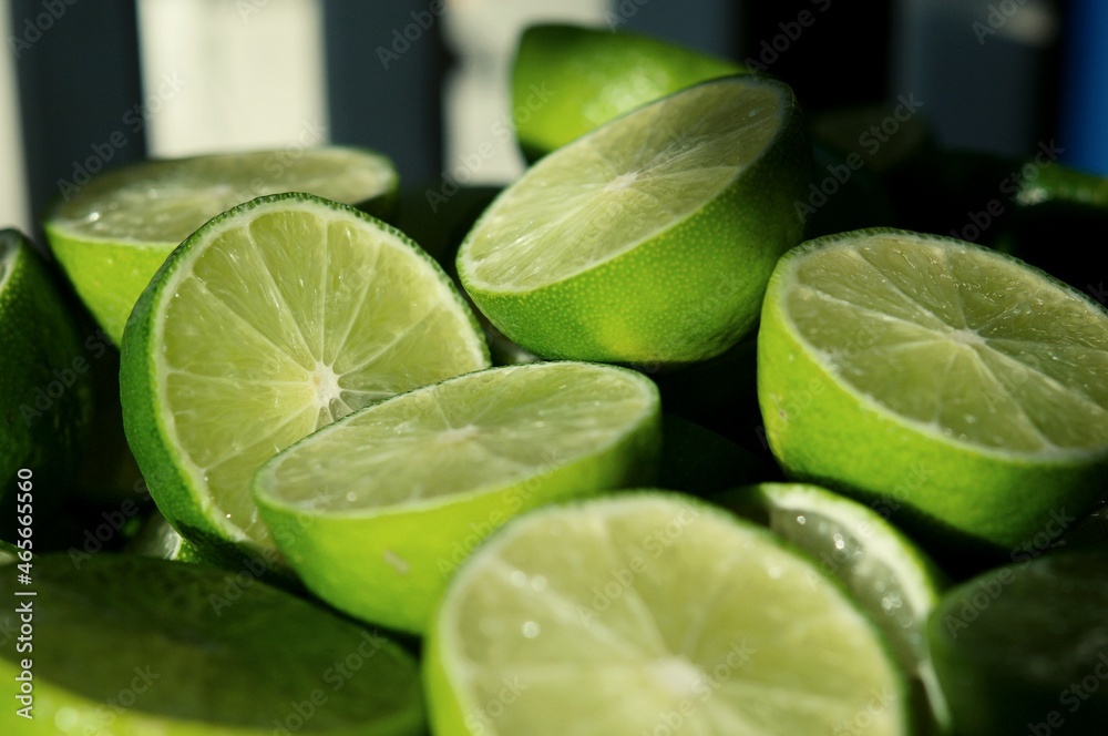 Lime Background with sunlight form outside. Close up shot of limes. Selective Focus of sliced lime. Lime is a kind of fruit. The result is very sour for cook the Thai food style Lime Background with sunlight form outside. Close up shot of limes. Selective Focus of sliced lime. Lime is a kind of fruit. The result is very sour for cook the Thai food style