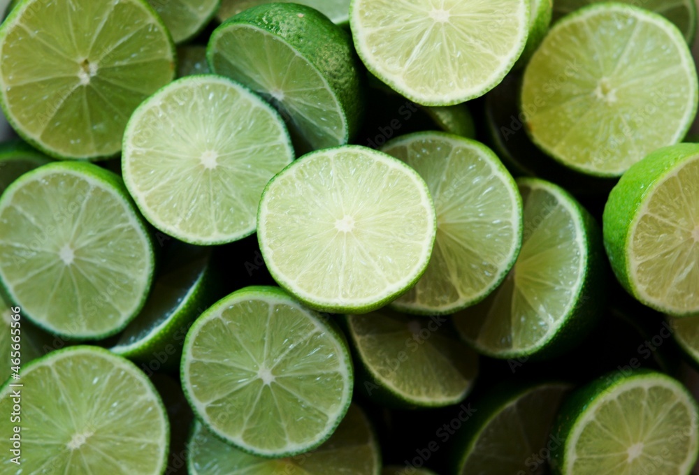 Lime Background with sunlight form outside. Close up shot of limes. Selective Focus of sliced lime. Lime is a kind of fruit. The result is very sour for cook the Thai food style