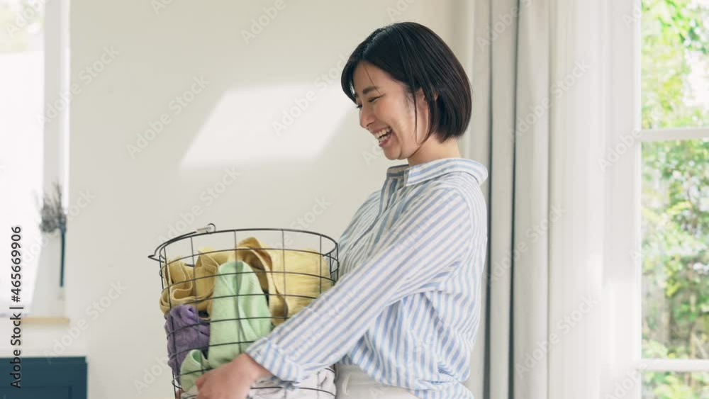 洗濯カゴを持つ笑顔の女性 洗濯カゴを持つ笑顔の女性