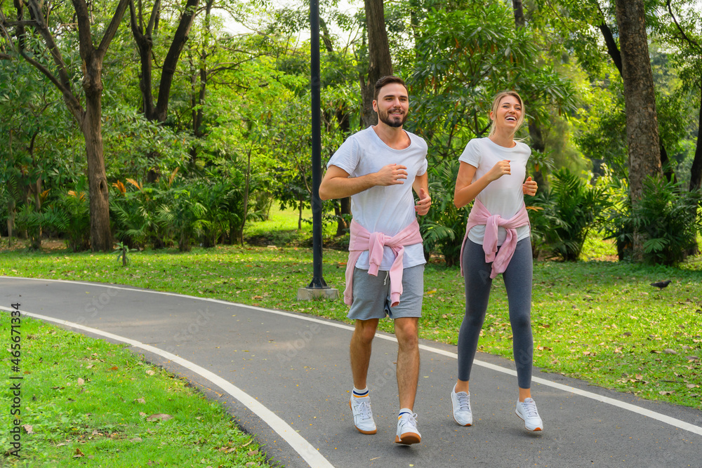 atheletic couple ijogging for exercise together in park