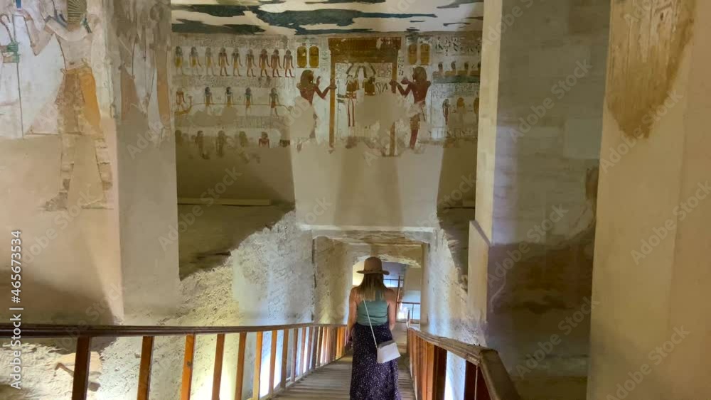Young woman with a hat descending the stairs of a sacred tomb that