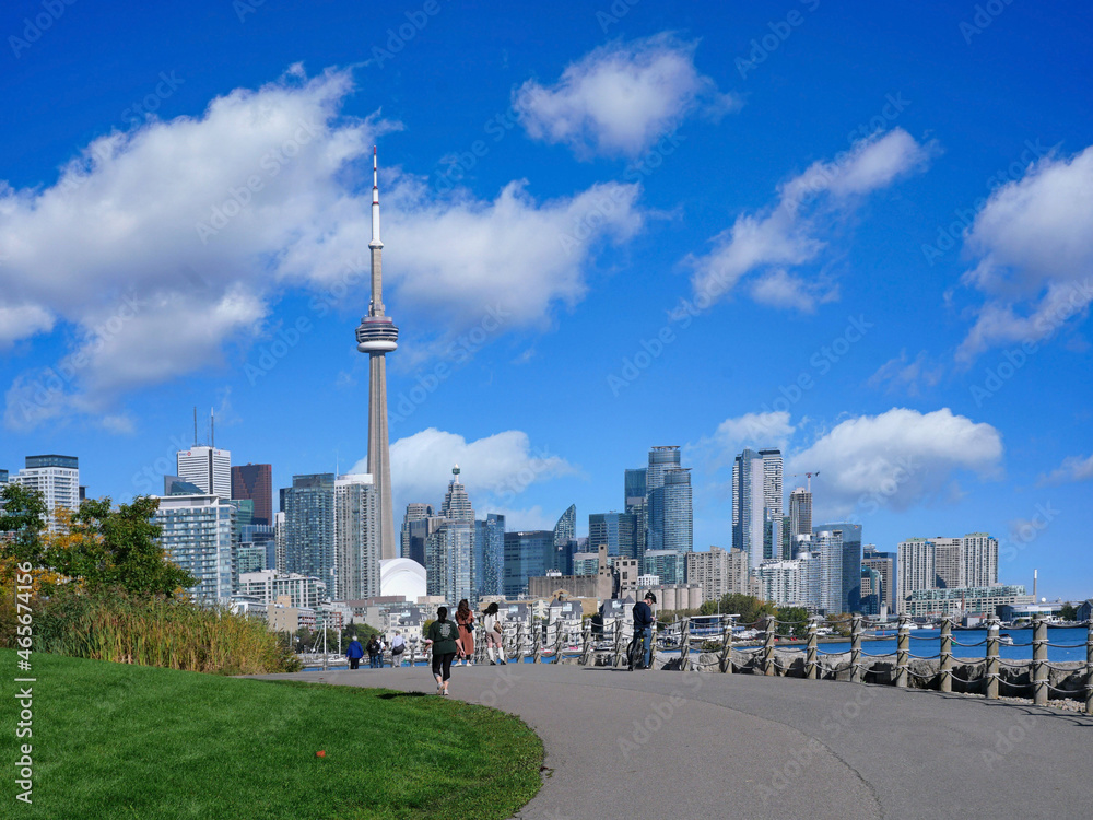 Fototapeta premium Toronto, Canada - October 27, 2021: Runners and cyclists enjoy a warm fall day on the recreational trail beside Lake Ontario near downtown Toronto.