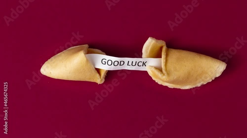 a stopmotion of a fortune cookie cracking and showing a prophecy, saying good luck