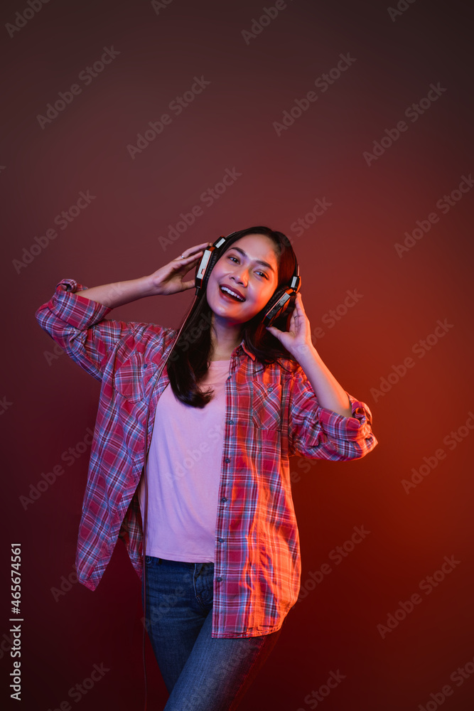 cheerful girl enjoying music using headphones with two hands holding headphones