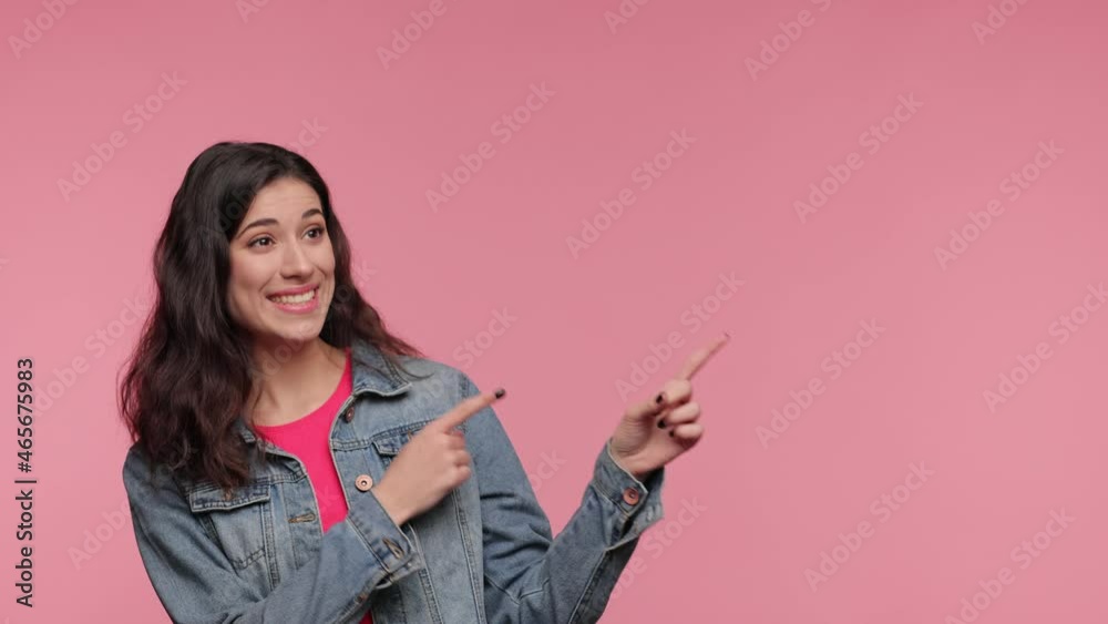 Shocked young woman 20s years old in casual denim jacket pink t-shirt posing look camera pointing fingers hands on copy space workspace isolated on pink background in studio. People lifestyle concept. Shocked young woman 20s years old in casual denim jacket pink t-shirt posing look camera pointing fingers hands on copy space workspace isolated on pink background in studio. People lifestyle concept.