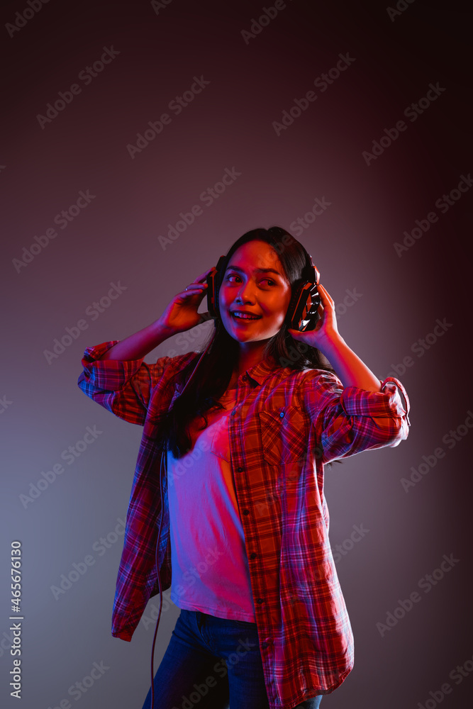beautiful woman listening to music while standing wearing headphones dancing