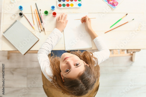 Cute little girl painting a...