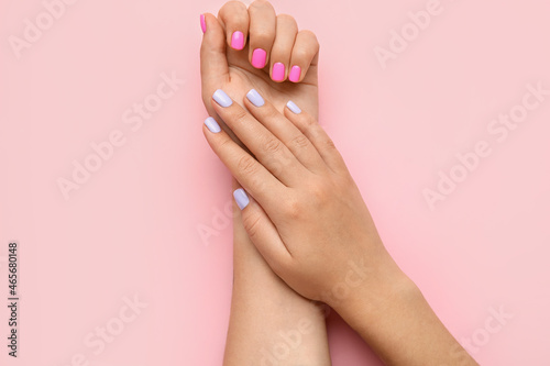Woman with different color nails on pink background