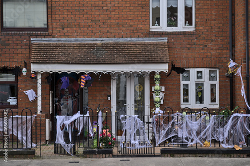 Beautiful and spooky Halloween decor on metal fence and typical Irish house in Dublin City Centre. Halloween 2021 decoration on the wall beside the door, Dublin, Ireland