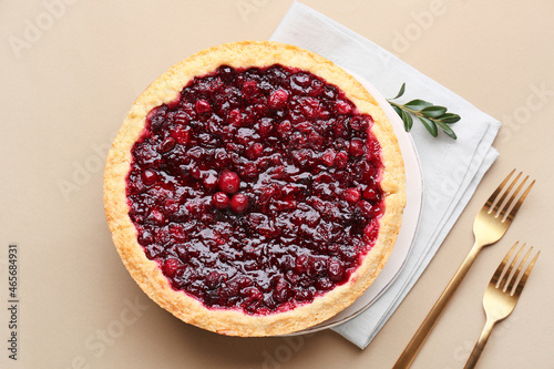 Plate with tasty homemade lingonberry pie on color background