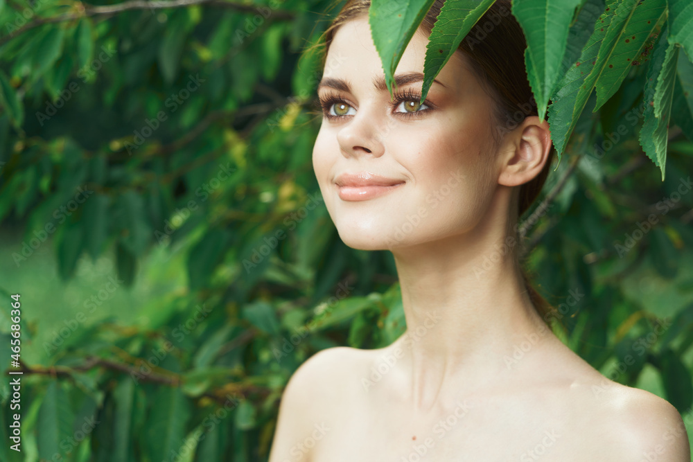 portrait of a woman attractive look bare shoulders green leaves cropped view portrait of a woman attractive look bare shoulders green leaves cropped view