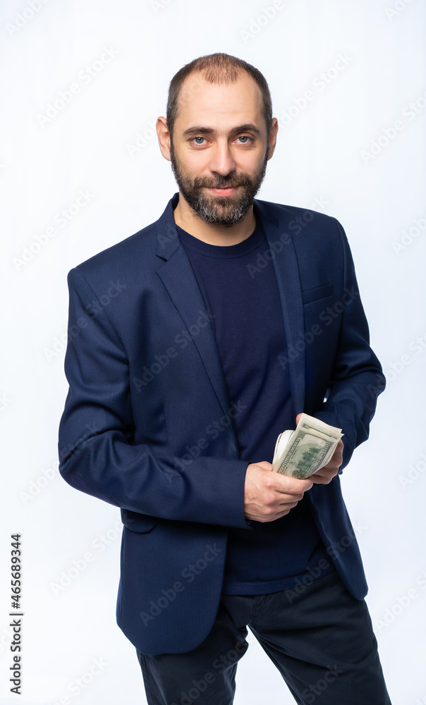 a man in a blue jacket and a T-shirt holds dollars. portrait of a brutal man. isolated white background a man in a blue jacket and a T-shirt holds dollars. portrait of a brutal man. isolated white background