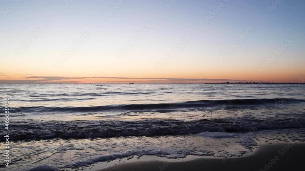 Showing The Sun Setting From St Kilda Beach, Looking Over Port Philip Bay, With Waves Rolling Onto The Beach. Melbourne, Victoria, Australia Showing The Sun Setting From St Kilda Beach, Looking Over Port Philip Bay, With Waves Rolling Onto The Beach. Melbourne, Victoria, Australia