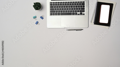 Top view laptop computer, smart phone and notebook on white background.
