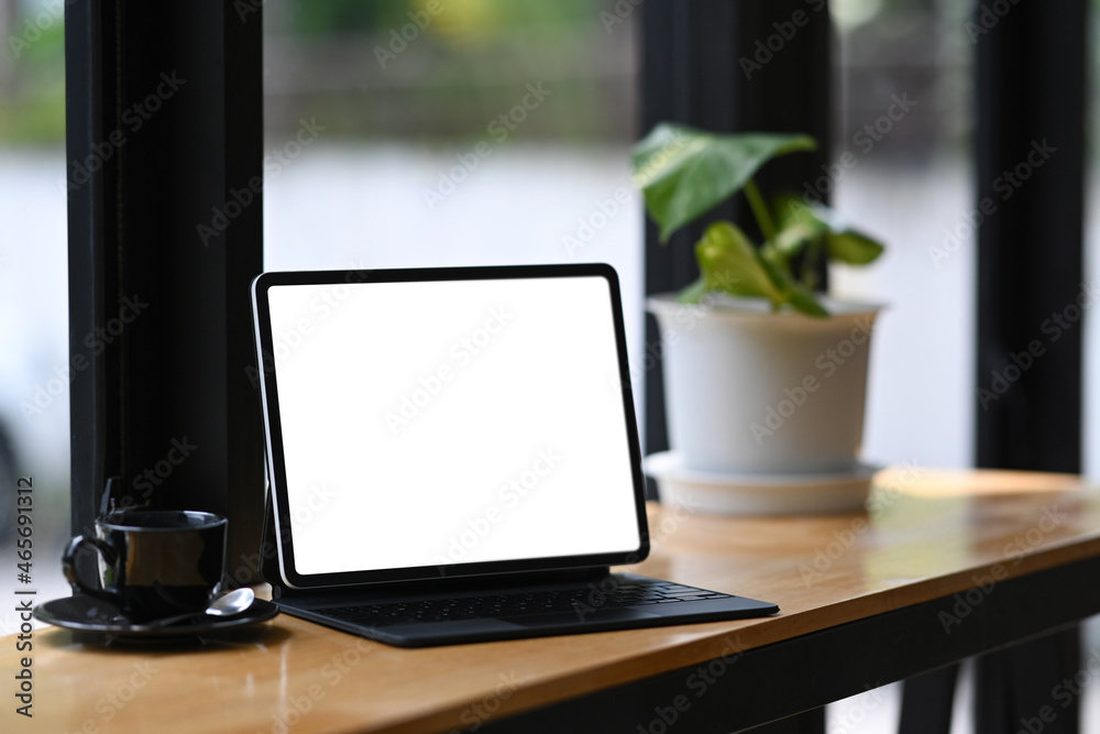 Mock up computer tablet, coffee cup and houseplant on wooden table. Mock up computer tablet, coffee cup and houseplant on wooden table.