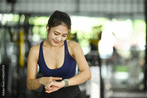 Young woman setting fitness app on her smartwatch before workout session. Free Download Young woman setting fitness app on her smartwatch before workout session. - GFXLoad