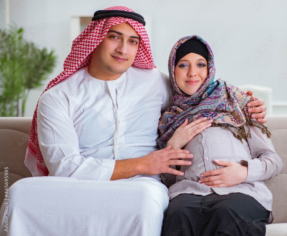 Young arab muslim family with pregnant wife expecting baby