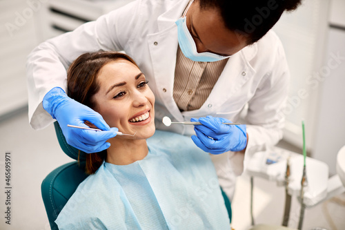 Young happy woman during dental procedure at dentist s office.