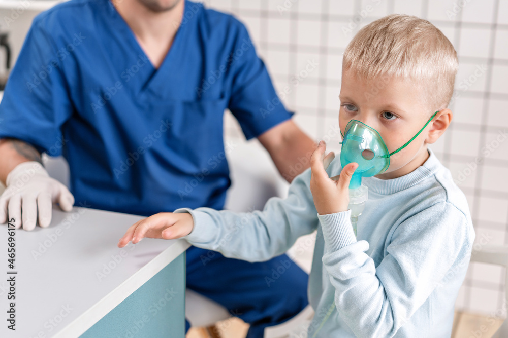 A pediatrician diagnoses lung disease and provides treatment. Breathe the medicine through a nebulizer inhaler.. Portrait of adorable little boy visiting doctor.