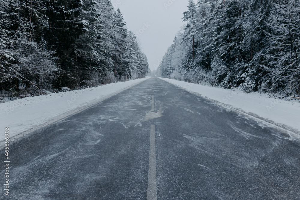 Winter road among forest with snowy fir trees. Snowy road in forest. Winter road among forest with snowy fir trees. Snowy road in forest.