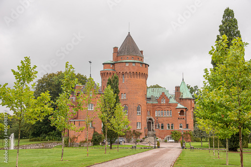 Hjularod castle is a romantick red castle inside a park on a green lawn photo