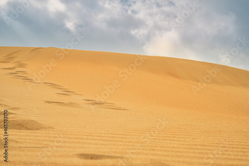 Footprints in the sand on a sand dune on the Black Sea coast. Close-up of a dune against the sky  summer idea banner