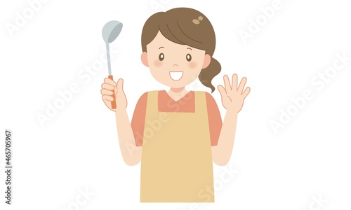 お玉を手にして笑顔のエプロン姿の女性