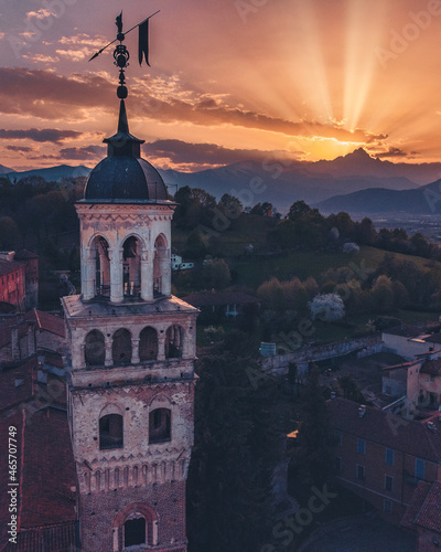 Foto La Torre Civica di Saluzzo col sole che tramonta dietro il Monviso