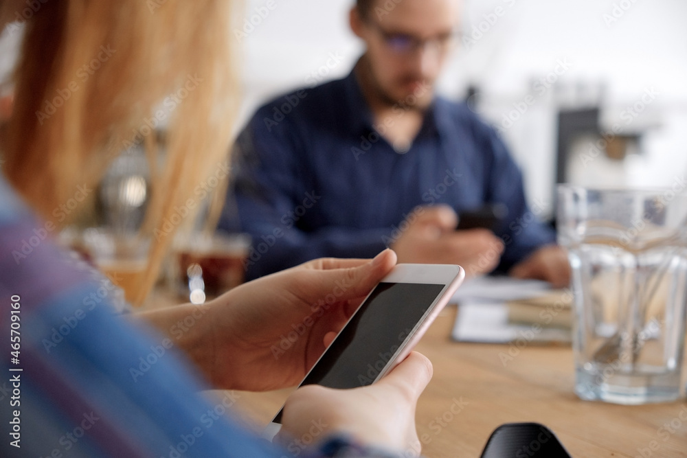Hand with smart phone screen against wooden table Hand with smart phone screen against wooden table