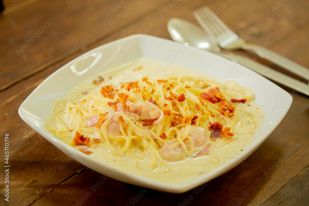 Creamy spaghetti carbonara on a plate at the main court table in this delicious and popular Italian restaurant. Creamy spaghetti carbonara on a plate at the main court table in this delicious and popular Italian restaurant.