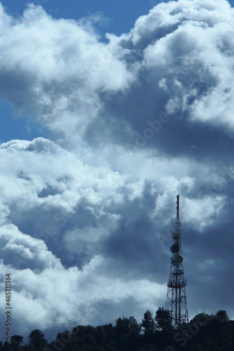 Backlit telecommunications antenna on a dramatic cloud day