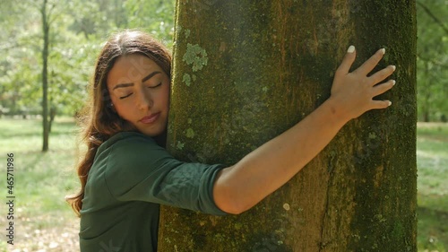 Woman hugging tree trunk in park photo
