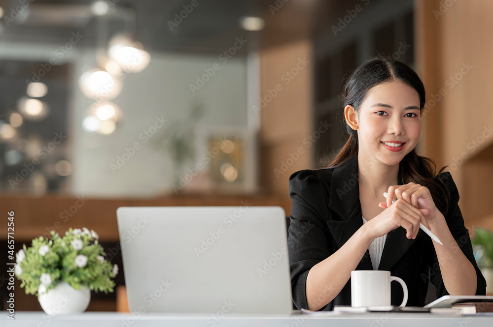 Young businesswoman smiling and looking at camra sitting at work.
