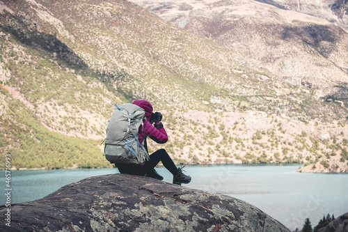Woman backpacker taking photo in beautiful winter mountains