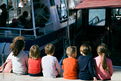 groupe d'enfants regardant les bateaux sur un quai photo