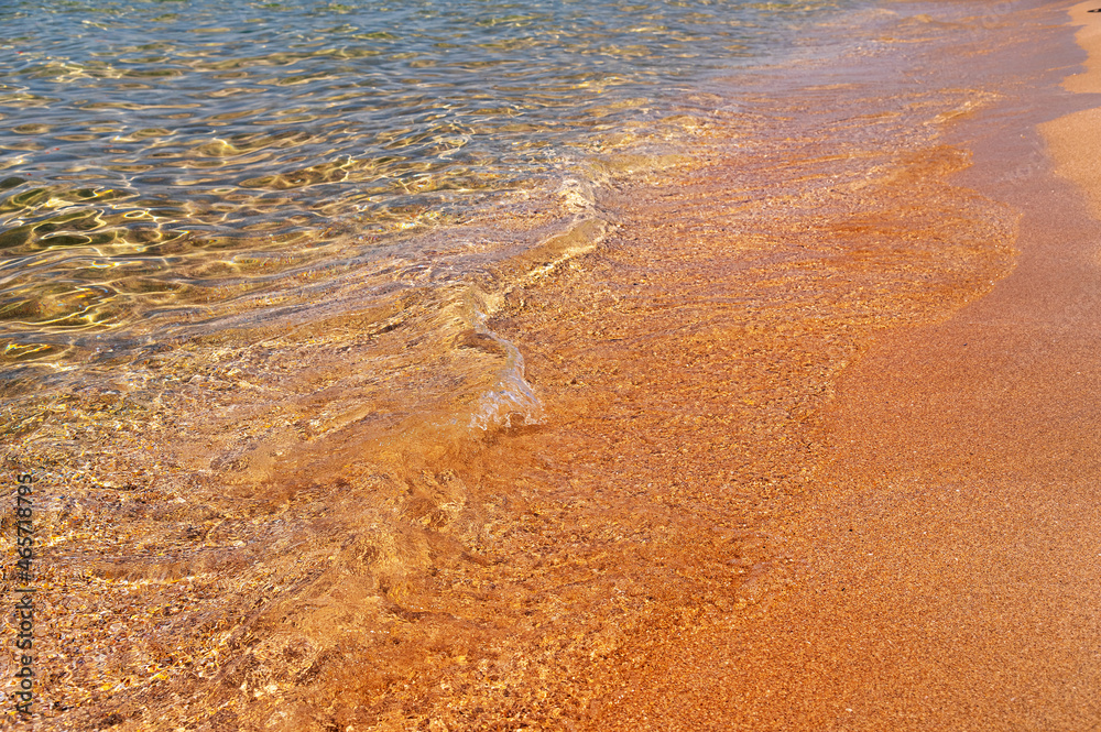 Transparent sea water. The golden sand is washed by small waves of clear water with foam. Marine background. tourism and travel Transparent sea water. The golden sand is washed by small waves of clear water with foam. Marine background. tourism and travel