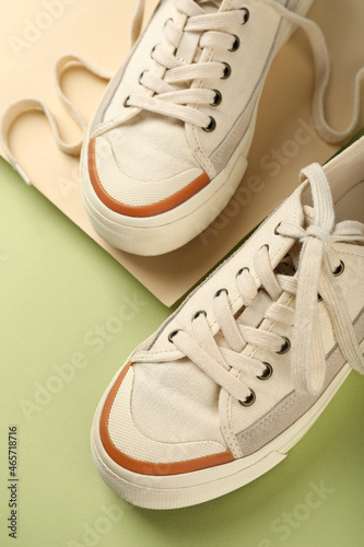 Pair of beige sneakers on two tone background