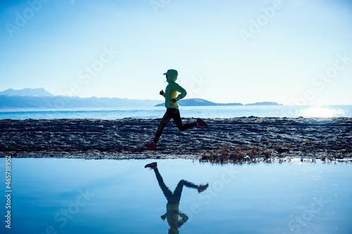 Woman trail runner running in winter lakeside © lzf
