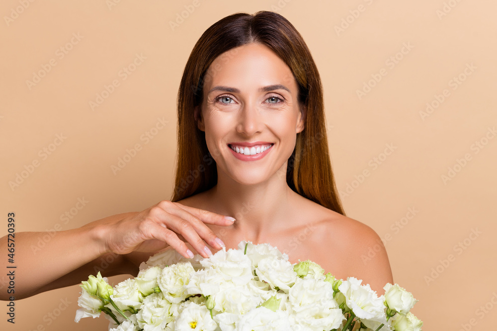 Portrait of attractive cheerful pure woman holding fresh floristic bunch dream isolated on beige pastel color background Portrait of attractive cheerful pure woman holding fresh floristic bunch dream isolated on beige pastel color background