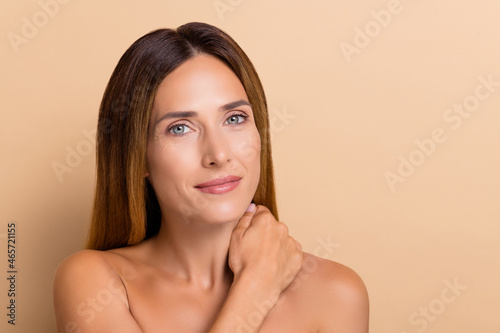 Portrait of attractive woman touching silky flawless skin hygiene cleansing pore isolated over beige pastel color background