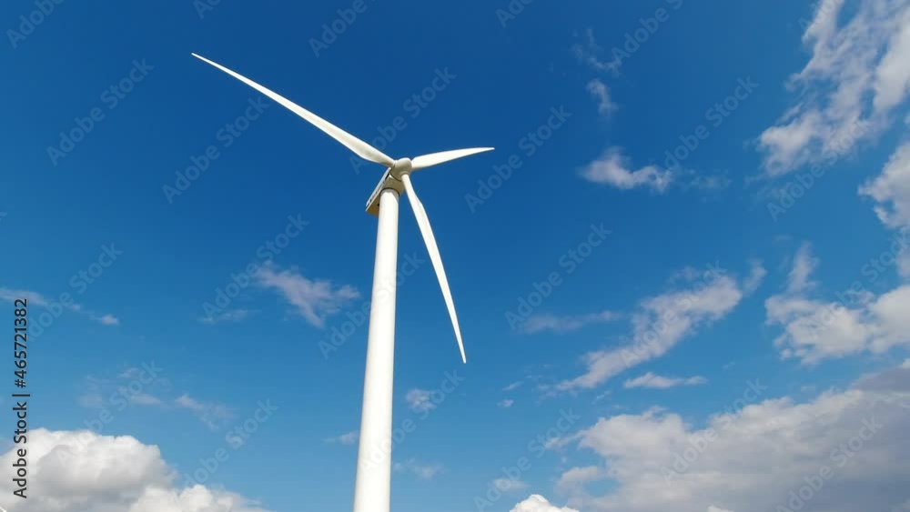 Wind turbine windmill with blades producing clean alternative renewable energy shot from low angle with sky background and space for text and graphics Wind turbine windmill with blades producing clean alternative renewable energy shot from low angle with sky background and space for text and graphics