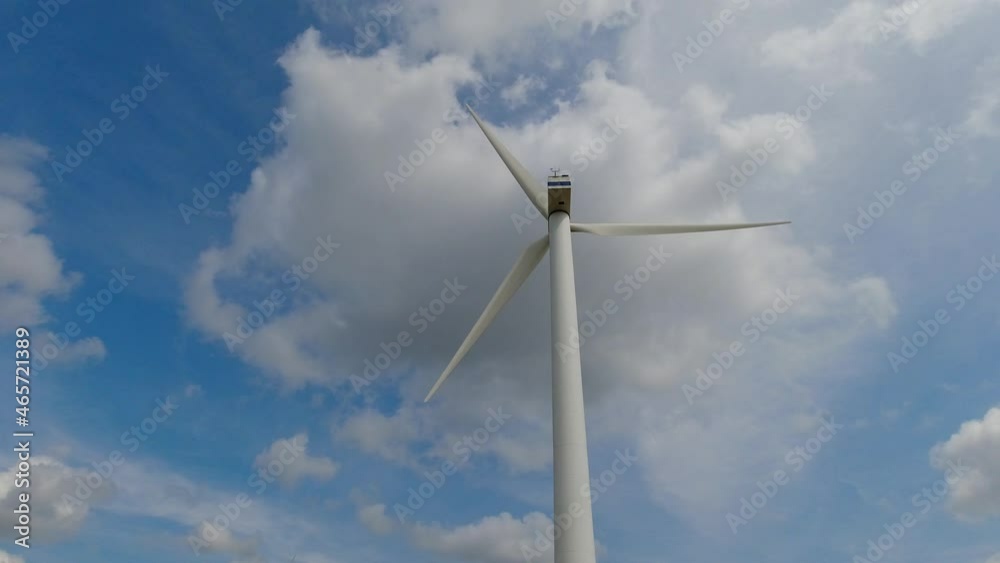 Wind turbine windmill with blades producing clean alternative renewable energy shot from low angle with sky background and space for text and graphics Wind turbine windmill with blades producing clean alternative renewable energy shot from low angle with sky background and space for text and graphics