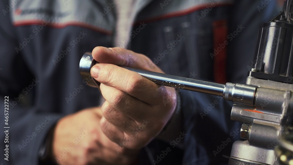 An auto mechanic works on a car engine in the mechanics ' garage. Repair services. Close-up