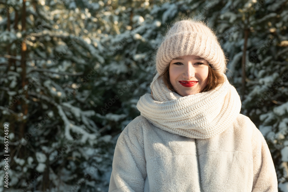 Portrait of young smiling woman in knitted hat and scarf in winter wood. Portrait of young smiling woman in knitted hat and scarf in winter wood.